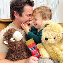 Man and child with stuffed animals and Enfamil Toddler formula bottle indoors